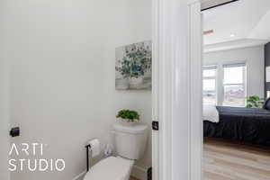 Ensuite bathroom featuring toilet and wood finished floors