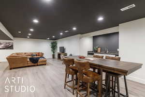Dining space with light wood-type flooring and recessed lighting