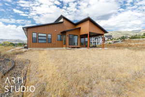 Back of property featuring a mountain view and a patio area