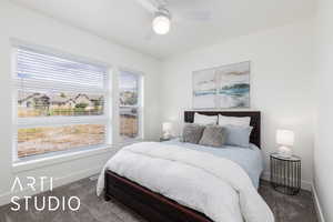 Carpeted bedroom featuring ceiling fan and baseboards
