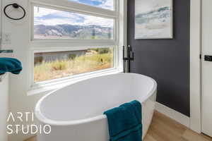 Primary Full bathroom with a soaking tub and wood finished floors