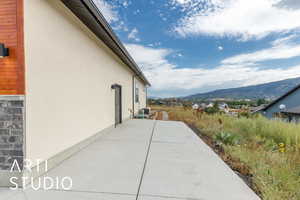View of side of property featuring a patio area, stucco siding, and a mountain view