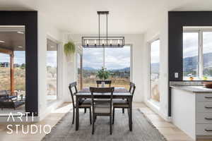 Dining area featuring a mountain view, light wood-style flooring, and healthy amount of natural light