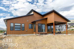 Rear view of house featuring a patio, board and batten siding, and a mountain view