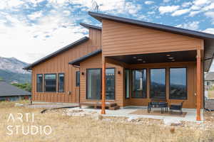 Back of house featuring a patio, board and batten siding, and a mountain view