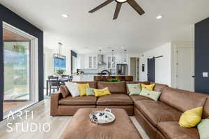 Living area featuring a barn door, recessed lighting, and light wood-style floors
