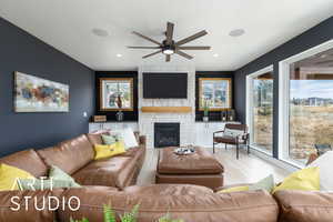 Living room featuring ceiling fan, wood finished floors, and a fireplace