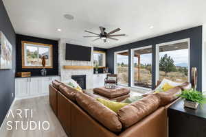 Living area with a fireplace, light wood-type flooring, a ceiling fan, and recessed lighting