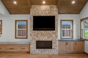 Unfurnished living room with vaulted ceiling, wood ceiling, and light wood-type flooring