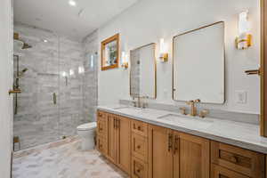 Full bath featuring a shower stall, double vanity, recessed lighting, and light tile patterned floors