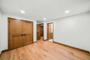 Unfurnished bedroom featuring light wood-type flooring, recessed lighting, and a closet