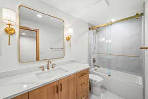 Bathroom featuring vanity, shower / bath combination with glass door, light tile patterned floors, and recessed lighting