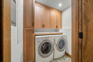 Washroom featuring cabinet space, independent washer and dryer, tile patterned flooring, and recessed lighting