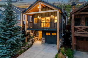 View of front of house with board and batten siding, driveway, an attached garage, and covered porch