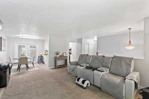 Living area with light carpet and french doors