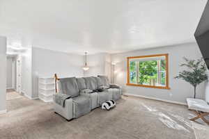 Carpeted living area featuring baseboards