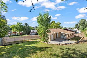 Rear view of property featuring a fenced backyard, a garage, a patio, concrete driveway, and stucco siding