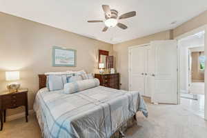 Bedroom featuring a closet, light carpet, and ceiling fan