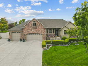 View of front of property featuring roof with shingles, covered porch, driveway, a front yard, and a garage