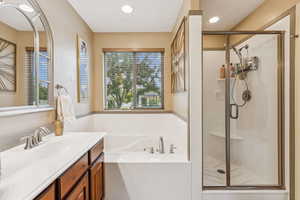 Bathroom with vanity, a garden tub, healthy amount of natural light, a stall shower, and recessed lighting