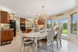 Dining room featuring a chandelier, light wood-style floors, and recessed lighting