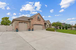 View of front of house featuring an attached garage, driveway, roof with shingles, and a gate