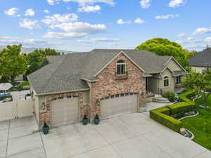 View of front of home featuring brick siding, driveway, roof with shingles, and a garage