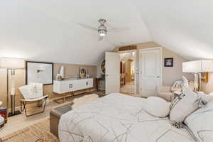 Bedroom with vaulted ceiling, light wood-style flooring, and ceiling fan