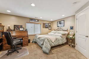 Bedroom featuring light carpet, recessed lighting, and a desk