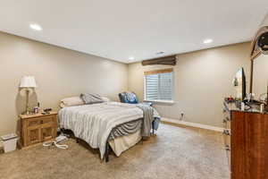 Bedroom with recessed lighting and light carpet