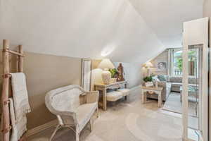 Sitting room with vaulted ceiling and light wood finished floors