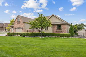View of front of home featuring brick siding, a garage, driveway, stucco siding, and a shingled roof