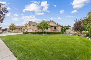 View of front of property featuring concrete driveway, stucco siding, a garage, and brick siding