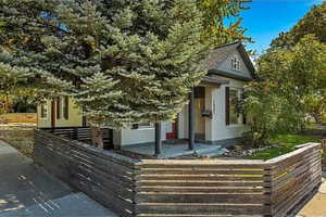 View of front of home featuring stucco siding, a fenced front yard, and covered porch