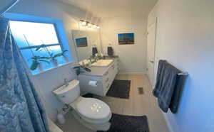 Full bath with vanity and light wood-type flooring