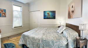Bedroom featuring wood finished floors and a closet