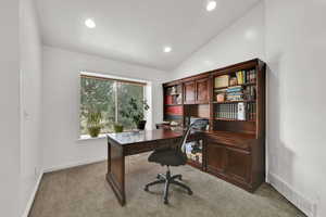 Office area with vaulted ceiling, light colored carpet, and recessed lighting