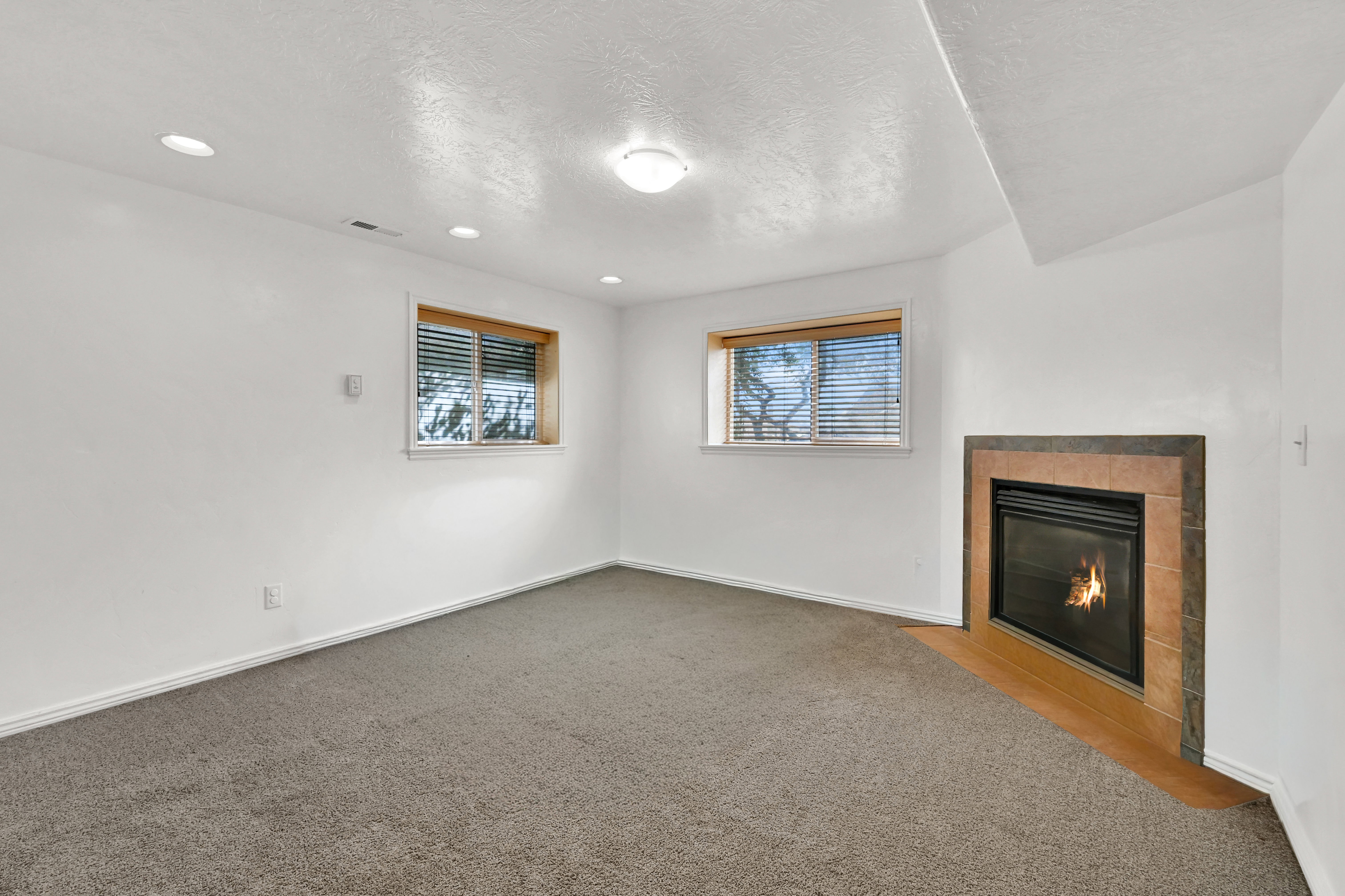 Bedroom with a fireplace, a textured ceiling, and carpet floors