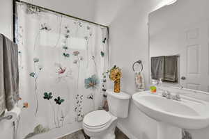 Bathroom featuring toilet and shower / bath combination with curtain