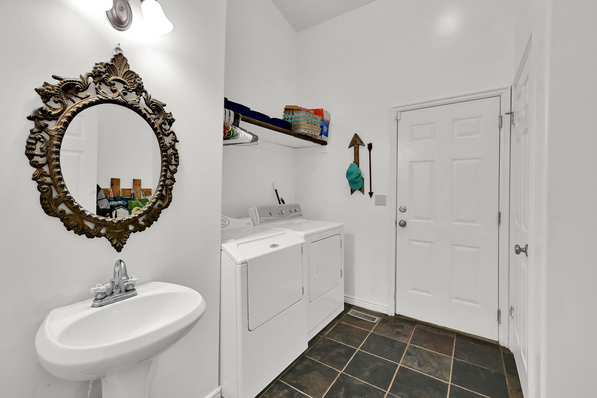 Laundry room with independent washer and dryer and dark tile patterned floors