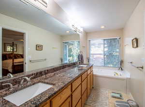 Full bath with connected bathroom, a bath, double vanity, light tile patterned flooring, and recessed lighting