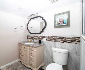 Half bath featuring vanity and tile walls