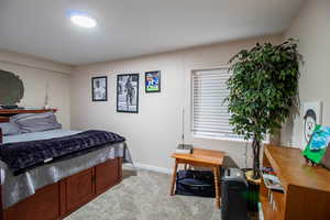 Bedroom featuring light colored carpet and baseboards