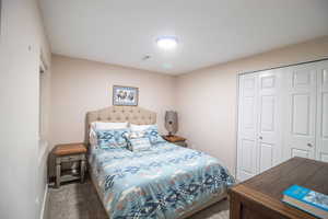 Carpeted bedroom with a closet