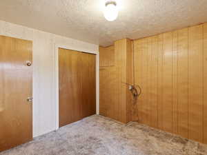Unfurnished bedroom with carpet flooring, a closet, and a textured ceiling