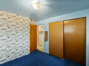 Unfurnished bedroom featuring a closet and carpet floors