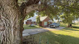 View of grassy yard featuring concrete driveway
