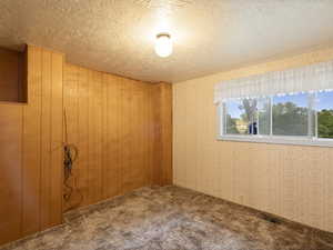 Carpeted empty room featuring a textured ceiling