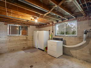 Below grade area with washer / clothes dryer and freestanding refrigerator