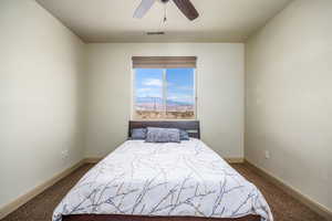 Bedroom with dark carpet, a mountain view, and ceiling fan